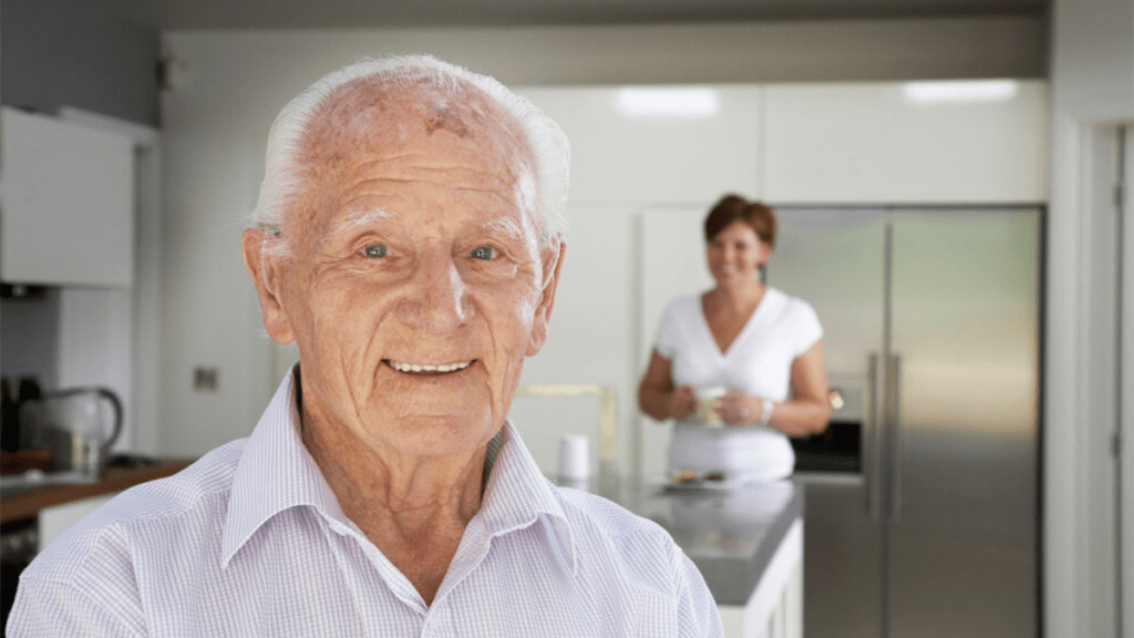 Elderly man standing in kitchen
