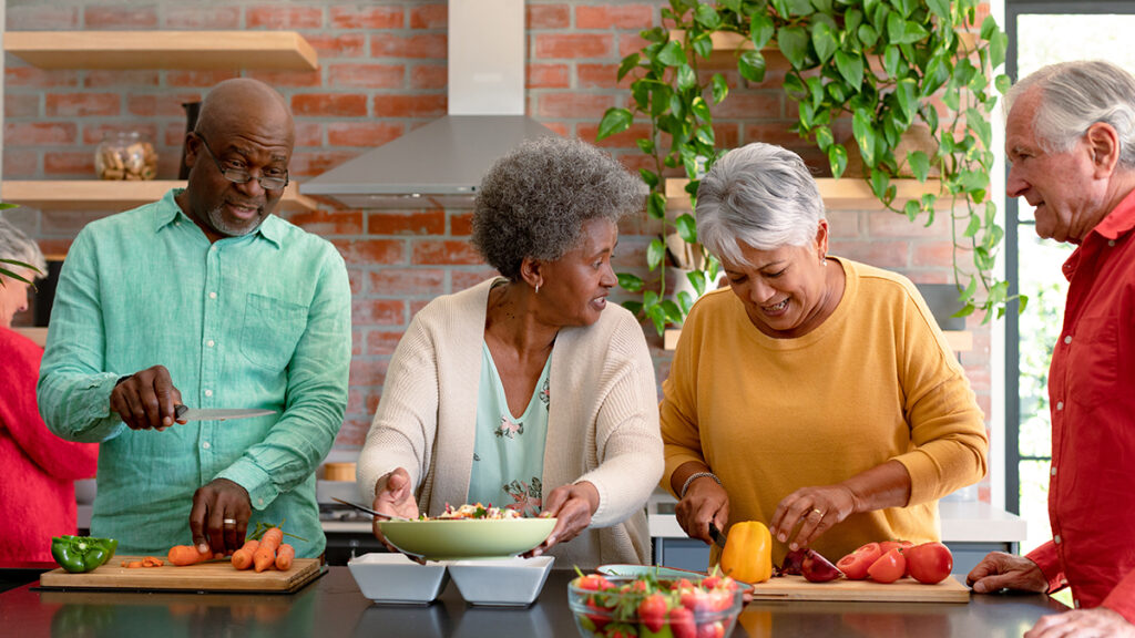 Group of elderly people preparing food in a kitchen